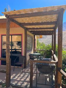 a wooden pergola with tables and chairs on a patio at Cabañas Miraelqui in Pisco Elqui