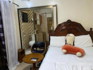 ein Schlafzimmer mit einem Bett mit einem ausgestopften Tier darauf in der Unterkunft Villa Palmeraie in Brazzaville