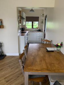 uma cozinha e sala de jantar com uma mesa de madeira em Kits Lodge Crover em Cavan