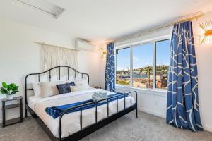 a bedroom with a bed with blue curtains and a window at Lakeview Charm BY Betterstay in Seattle