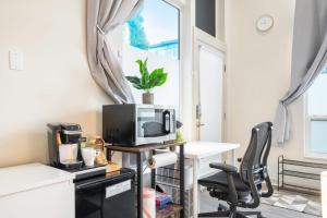 a room with a desk with a microwave and a computer at Cozy & Private Studio in the Heart of Fremont in Seattle