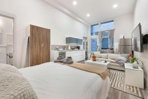 a white bedroom with a large bed and a living room at The Canal 15D BY Betterstay in Seattle