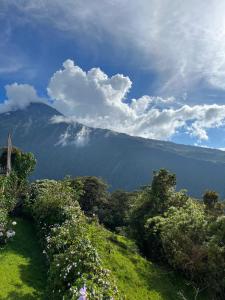 vista su una catena montuosa con alberi e nuvole di First Class Hotel en Baños - Ciudad Volcan a Baños