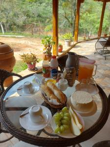 una mesa con desayuno de pan y fruta en Recanto Casa Amarela, en Miguel Pereira