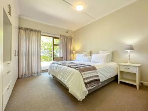 una camera da letto con un letto grande e una finestra di Chalet 33, Silver Ranch, Plettenberg Bay a Plettenberg Bay