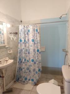 a bathroom with a shower curtain with a toilet and a sink at LUZ MAR San Clemente del Tuyú in San Clemente del Tuyú