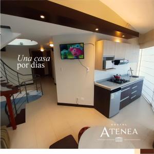 eine Küche mit einem TV an der Wand und einem Tisch in der Unterkunft Apart Hotel Atenea in Ilo