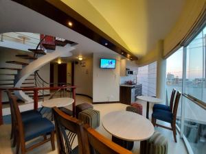 une chambre avec deux tables et des chaises et un escalier dans l'établissement Apart Hotel Atenea, à Ilo