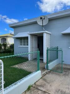 a white house with a gate in front of it at Apt 1 Lynsted - Newly renovated 2 bed 1 bath in Bridgetown