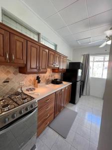 a kitchen with wooden cabinets and a stove top oven at Apt 1 Lynsted - Newly renovated 2 bed 1 bath in Bridgetown