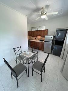a kitchen with a table and chairs and a refrigerator at Apt 1 Lynsted - Newly renovated 2 bed 1 bath in Bridgetown