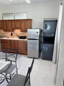 a kitchen with a refrigerator and a table and chairs at Apt 1 Lynsted - Newly renovated 2 bed 1 bath in Bridgetown