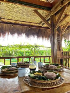 a wooden table with plates of food on it at Joseph Agricultural Farm in Ubay