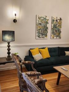 a living room with a green couch with yellow pillows at Baires Art Decó in Buenos Aires