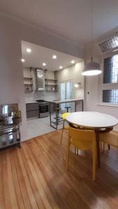 a kitchen and dining room with a table and yellow chairs at Baires Art Decó in Buenos Aires