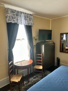 a bedroom with a bed and a table and a window at Belmont Inn in Shelbyville