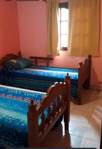 a bedroom with two twin beds and a window at Mis Vacaciones in Necochea