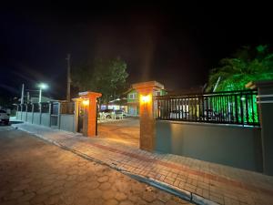 a street at night with a fence and lights at Vila Madu in Bombinhas
