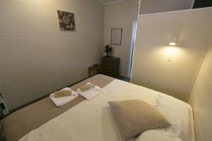 a bedroom with a bed with two towels on it at Maple Lodge Motel in Matamata