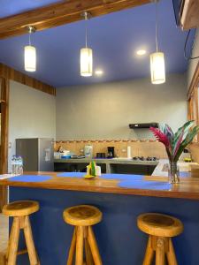 a kitchen with a counter with two stools at Jazlyn Lodge in Paquera