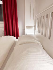 duas camas num quarto com uma cortina vermelha em Lola’s apartament close to city center em Bucareste