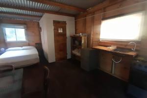 a bedroom with a bed and a sink and a window at Cabaña de playa Rústica cerca al mar - Matu in Sauce de Portezuelo