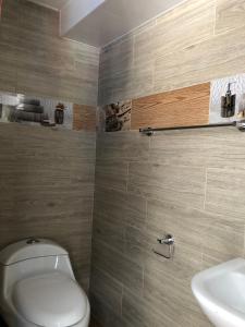 a bathroom with a toilet and a sink at First Class Hotel en Baños - Ciudad Volcan in Baños