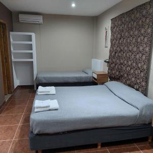 two beds in a room with towels on them at Hotel Segundo Roma in Villa La Paz
