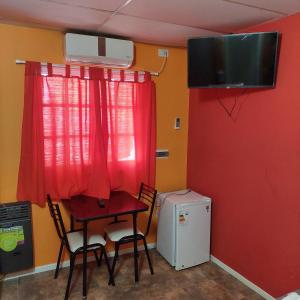 a dining room with a table and a small refrigerator at Hotel Segundo Roma in Villa La Paz