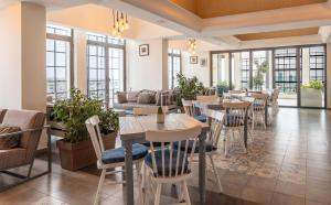 a restaurant with tables and chairs and windows at Crowne Plaza Amman by IHG in Amman