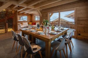 a dining room with a wooden table and chairs at Chalet Trusquin - OVO Network in Le Grand-Bornand