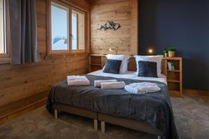 a bedroom with a bed with towels on it at Chalet Trusquin - OVO Network in Le Grand-Bornand