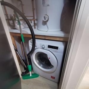 uma máquina de lavar roupa com uma mangueira ao lado de uma máquina de lavar roupa em 1 Bed Apartment in Cardiff Bay -Dixie Buildings em Cardiff