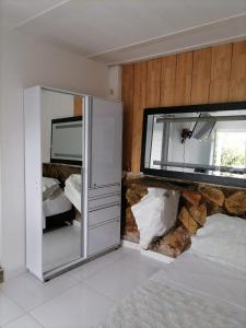 una camera da letto con un letto e uno specchio a parete di Finca Mirador la Giralda a Roldanillo