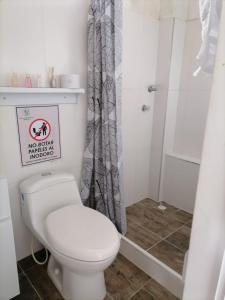 a bathroom with a white toilet and a shower at Finca Mirador la Giralda in Roldanillo
