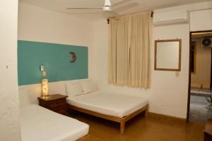 a living room with two beds and a mirror at Hotel San Lorenzo in Barra de Navidad