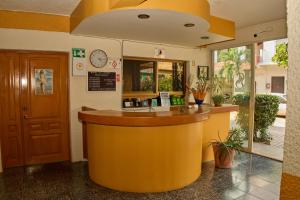 a restaurant with a yellow counter in a building at Hotel San Lorenzo in Barra de Navidad
