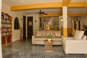 a living room with two couches and a ceiling fan at Hotel San Lorenzo in Barra de Navidad