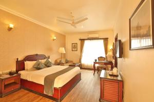 a hotel room with a bed and a television at The Lindsay in Kolkata