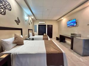 um quarto de hotel com duas camas e uma televisão de ecrã plano em Hotel Yorio Inn em Tuxpan de Rodríguez Cano