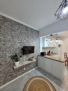 una cucina e un soggiorno con un muro di mattoni di Azores village apartments a Fontinhas
