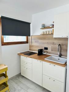a kitchen with white cabinets and a sink and a window at Casa Amanda in Sestriere