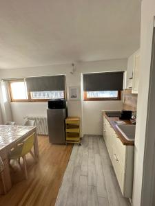 a kitchen with white cabinets and a table and a refrigerator at Casa Amanda in Sestriere
