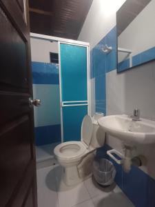 a blue and white bathroom with a toilet and a sink at Apartahotel San Miguel in San Gil