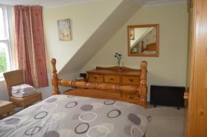 a bedroom with a bed and a dresser and a mirror at Holiday Apartment Dunfermline in Dunfermline