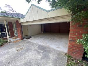 un garaje con un edificio de ladrillo y una puerta de garaje en Beautiful 3BR Home by Dandenong Creek, en Bayswater