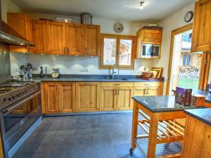 a large kitchen with wooden cabinets and a sink at Chalet de luxe avec cheminée, terrasse, garage à Morzine - FR-1-524-14 in Morzine