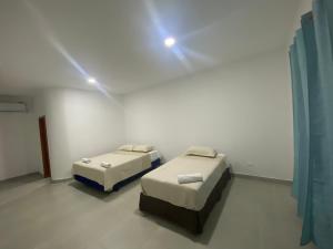 two beds in a room with lights on the wall at Penguin House in Puerto Villamil