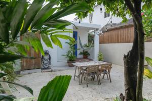 a table and chairs in the courtyard of a house at Dream Beach House by Sonsoleá Host in Luquillo