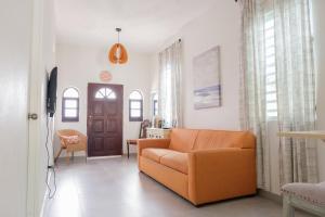 a living room with an orange couch and a door at Dream Beach House by Sonsoleá Host in Luquillo